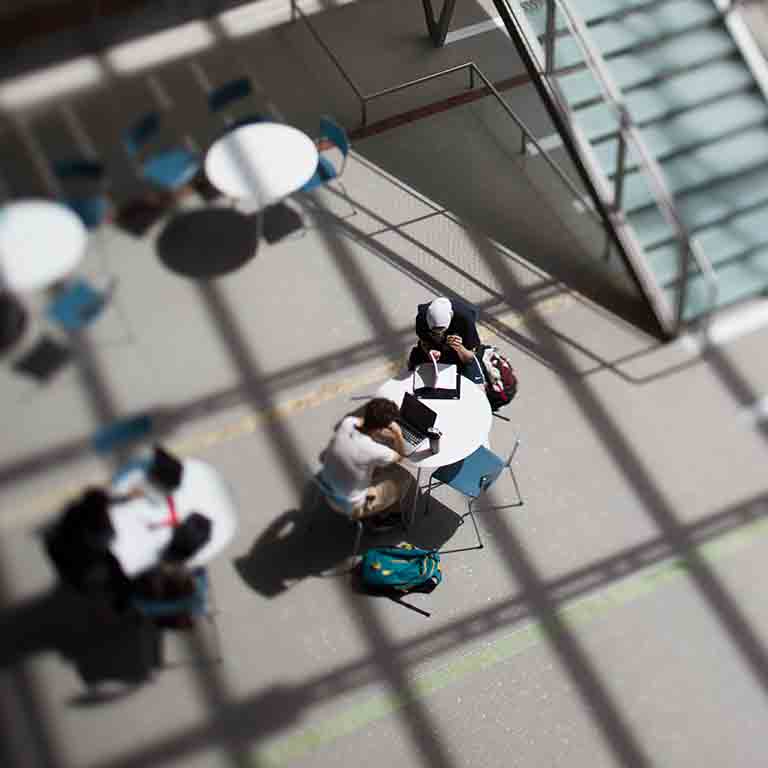 学生们围坐在全球与国际研究大楼的一张桌子旁。